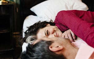 Smiling couple lying in bed